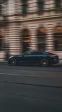 Dunkelgrüne Limousine fährt durch eine Stadtstraße